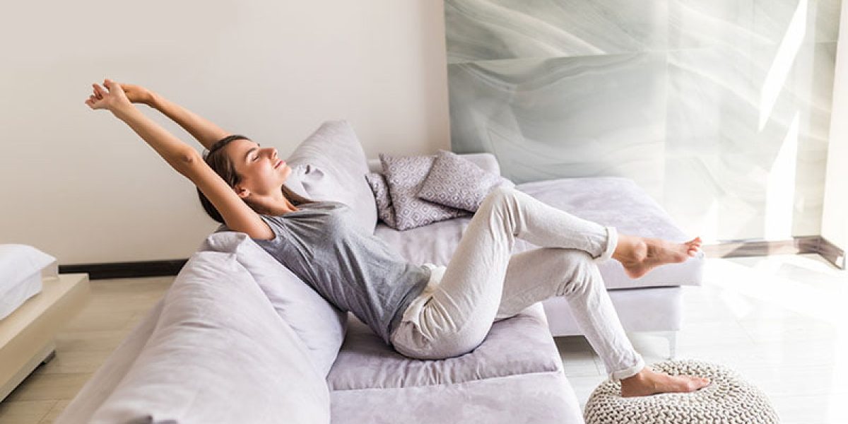 Closeup of a smiling young woman lying on couch